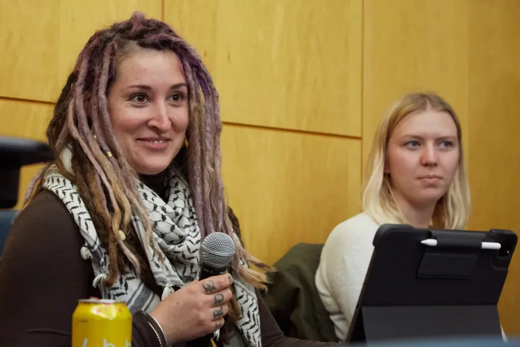 A U N E graduate student uses a microphone to ask a C G H speaker a question